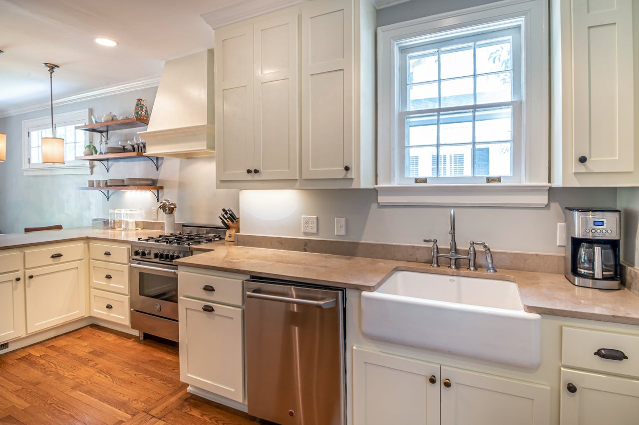 Bright kitchen with wooden floors and modern white cabinetry.