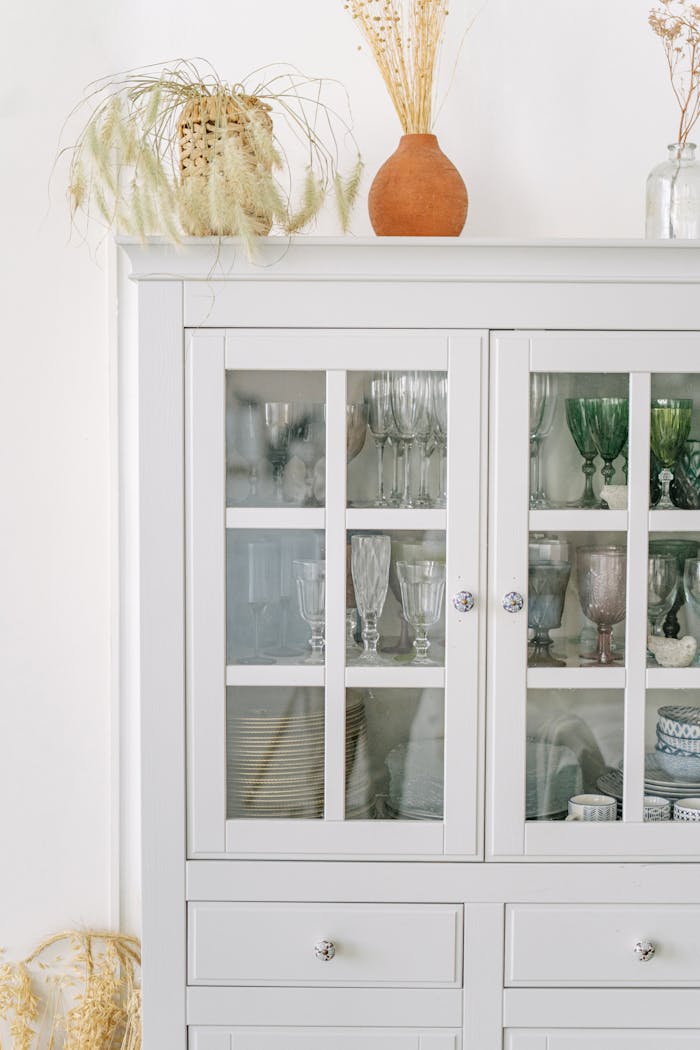 services-bg Minimalist white cabinet with elegant glassware and decor, adding a touch of sophistication.