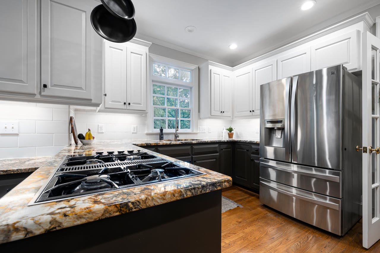 Bright modern kitchen with stainless steel fridge and elegant countertops.